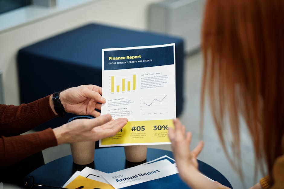 Two individuals analyzing a finance report chart at a business meeting in an office setting.